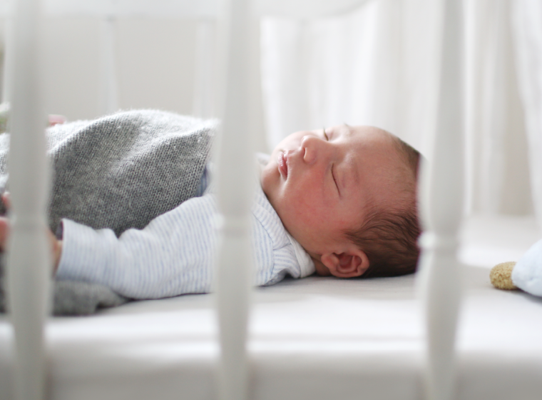 A baby sleeping peacefully in a crib. Exponent studies human factors to advance the safety and compliance of children's products.