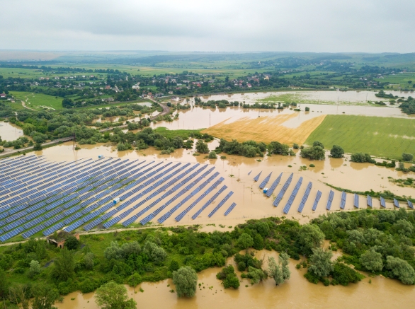 Aerial view of flooded solar power station with dirty river water in rain season