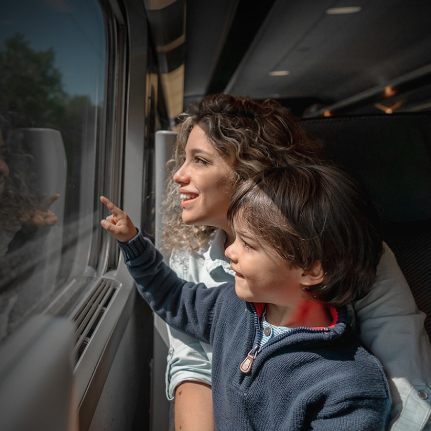 Parent and child look out a train window. Exponent engineers and scientists help improve the safety and performance of products.