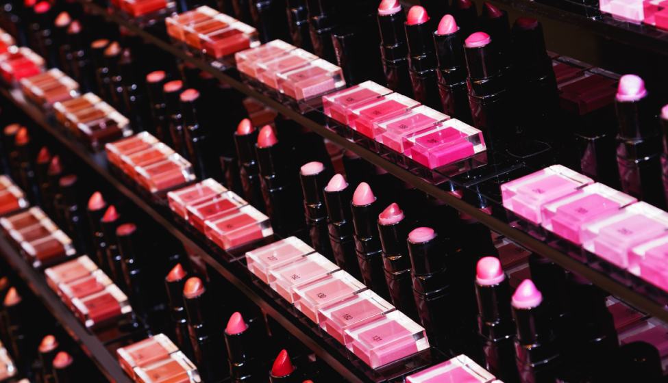 A display shelf in a cosmetic store filled with rows of lipsticks in various shades