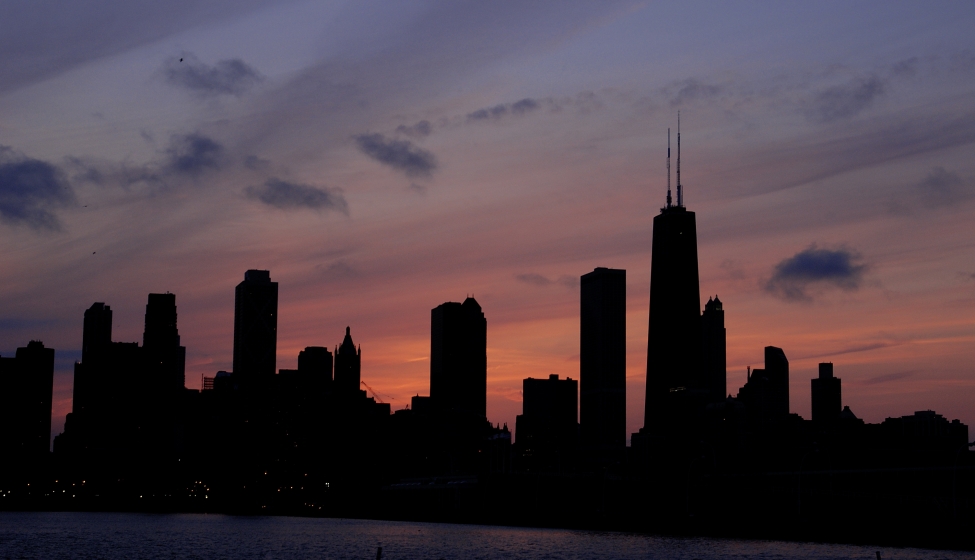 The Chicago Skyline is silhouetted aginst the setting sun.