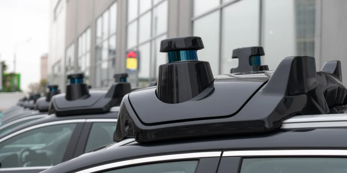 Close-up view of sensors and radar on roof of black autonomous driving vehicle 
