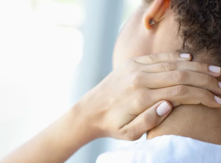 Person massaging their neck pain. Exponent helps bring safe, innovative, next-generation medical devices to market. 