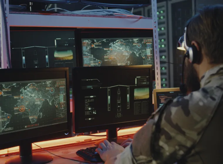 Medium close-up of soldiers controlling rocket launch on computer