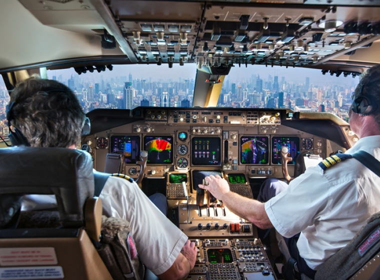 Two commercial airline pilots in the cockpit of a jet airplane. Exponent engineers provide expertise for aviation and aerospace. 