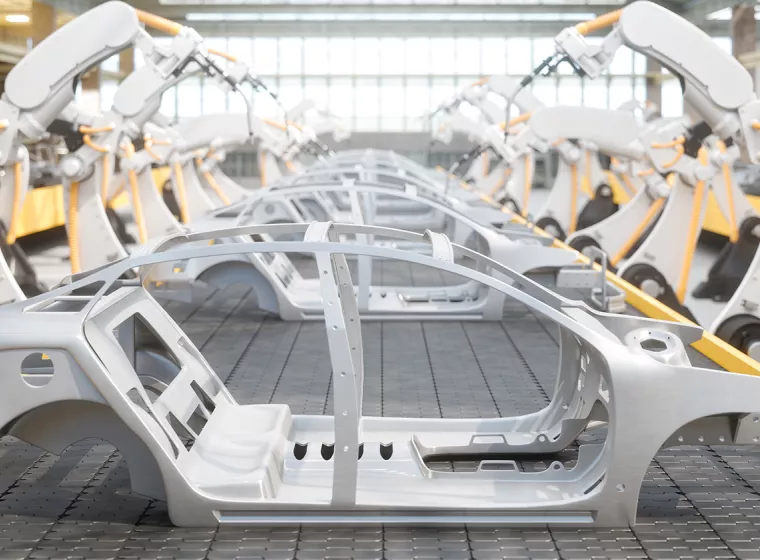 A side view of car frames on a robotic assembly line. Exponent provides support for all vehicle engineering challenges.