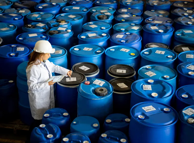 Foreperson doing quality control on a stock of chemical barrels 