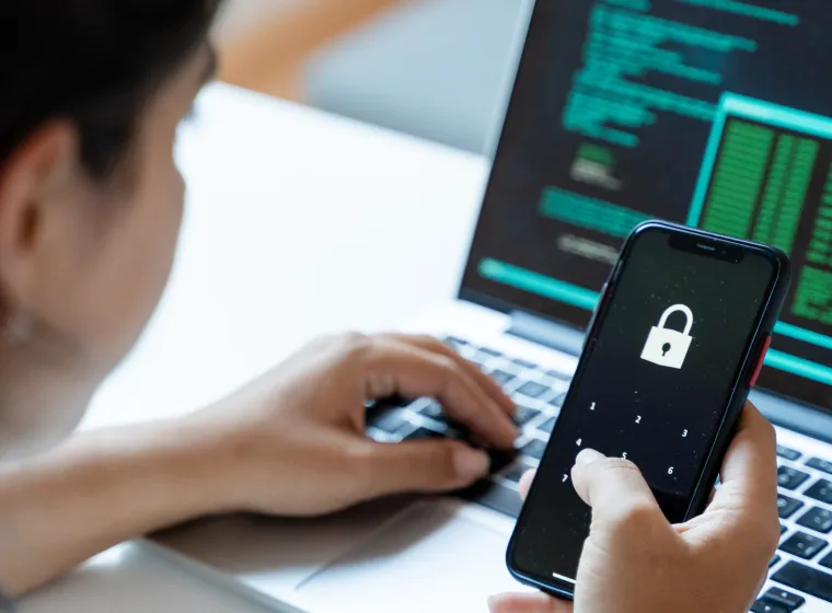 Woman using mobile phone and laptop computer at home