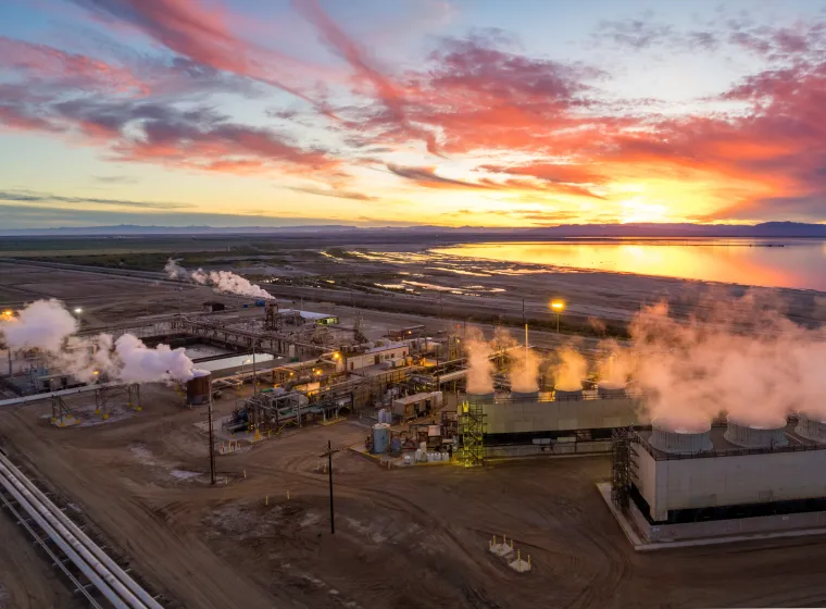 Aerial view of steam rising above an industrial Geothermal Power Plant, Salton Sea in the distance