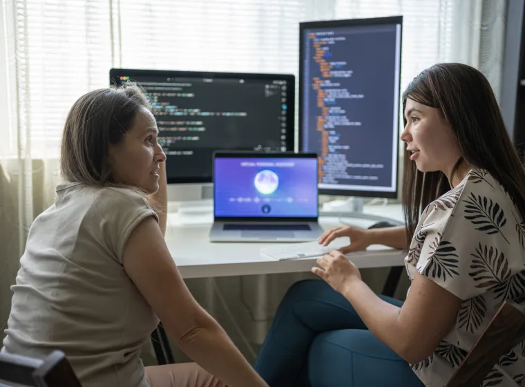 Two Female Programmers Learning To Code In Modern Office Using AI