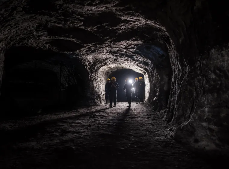 Group of men in a dark mine underground - mining concepts