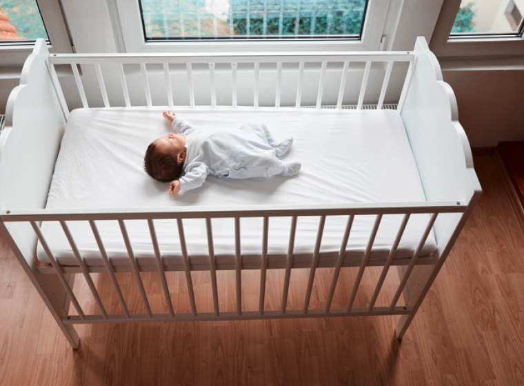 Baby in a crib. Exponent helps improve the safety, and compliance of children's products with safety evaluations and risk assessments.