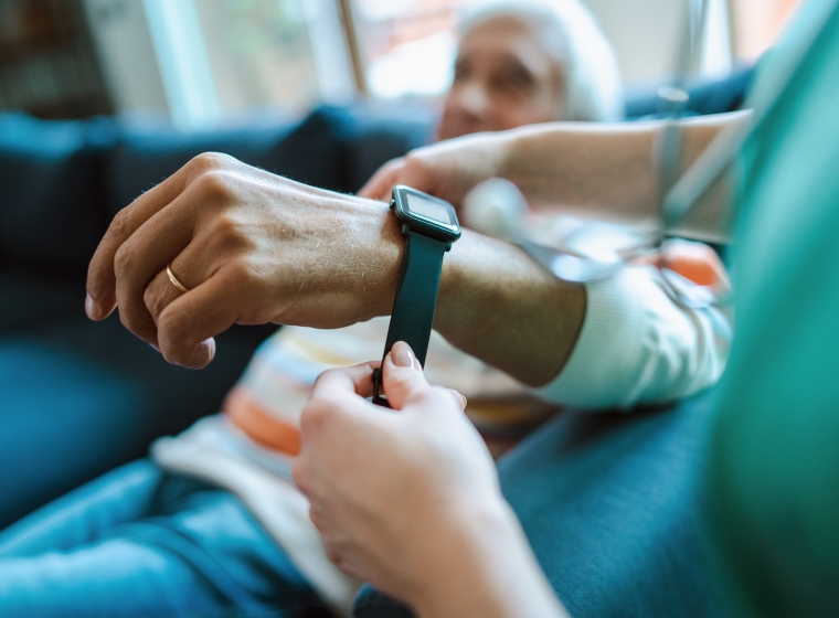 An elderly patient being fitted with a digital health wrist wearable