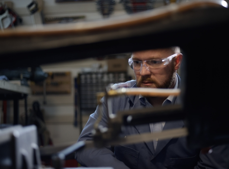 A worker examines mechanical components in Exponent's Natick research laboratory. 