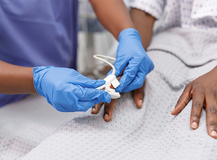 Nurse using pulse oximeter on hospitalized patient