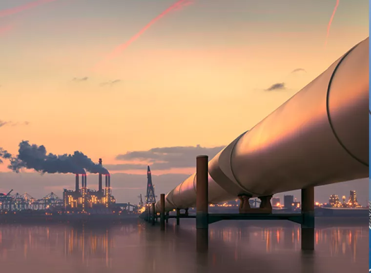 Oil pipeline stretching over the ocean with city background. Exponent helps improve efficiency and safety of oil and gas pipeline.