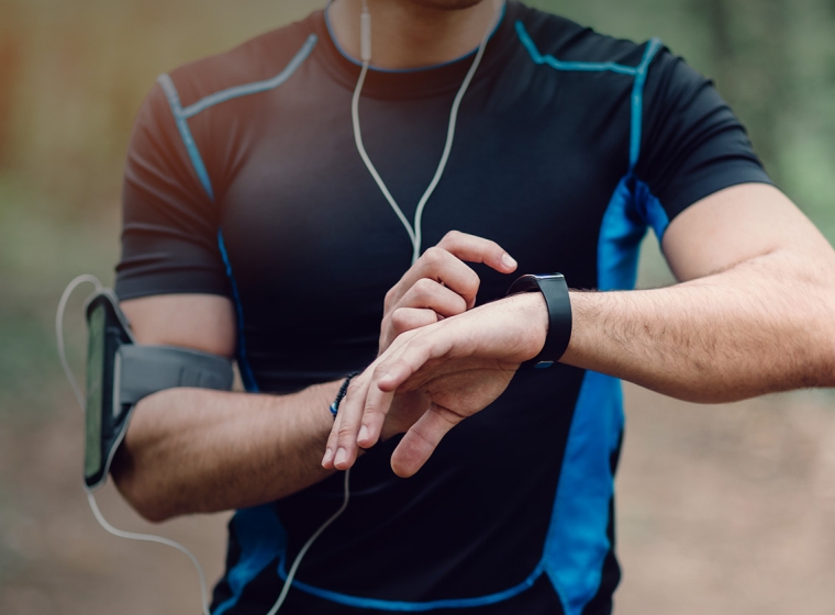 A runner stops to check their smartwatch. Exponent collects real-world evidence and expands data acquisition capabilities to improve healthcare. 