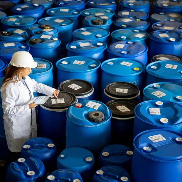 Foreperson doing quality control on a stock of chemical barrels 