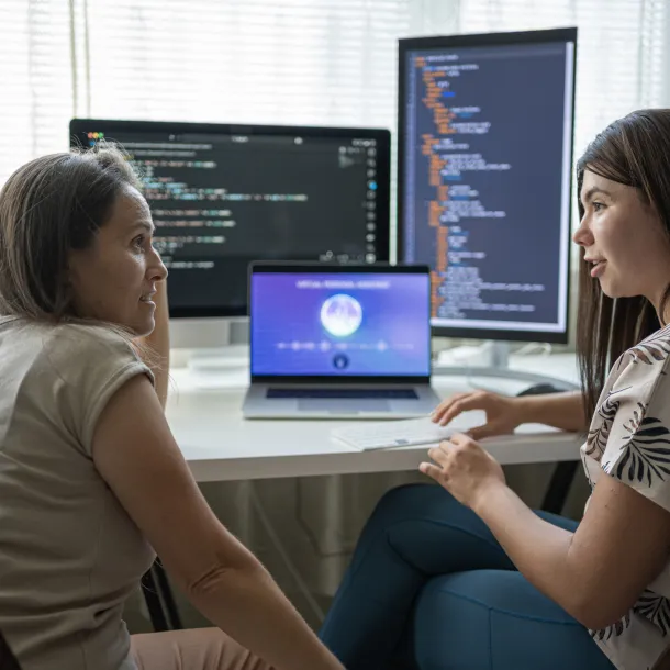 Two Female Programmers Learning To Code In Modern Office Using AI