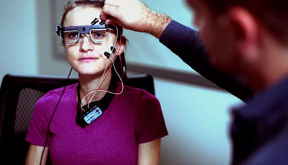 Exponent scientists attach bio sensors to a young person in a user experience lab to monitor movement.