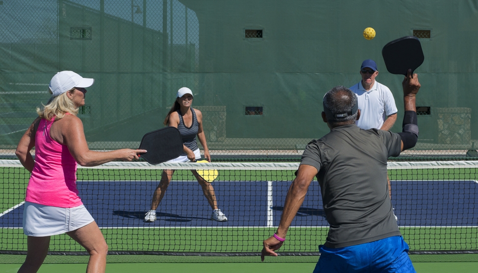 Two couples playing a game of pickleball