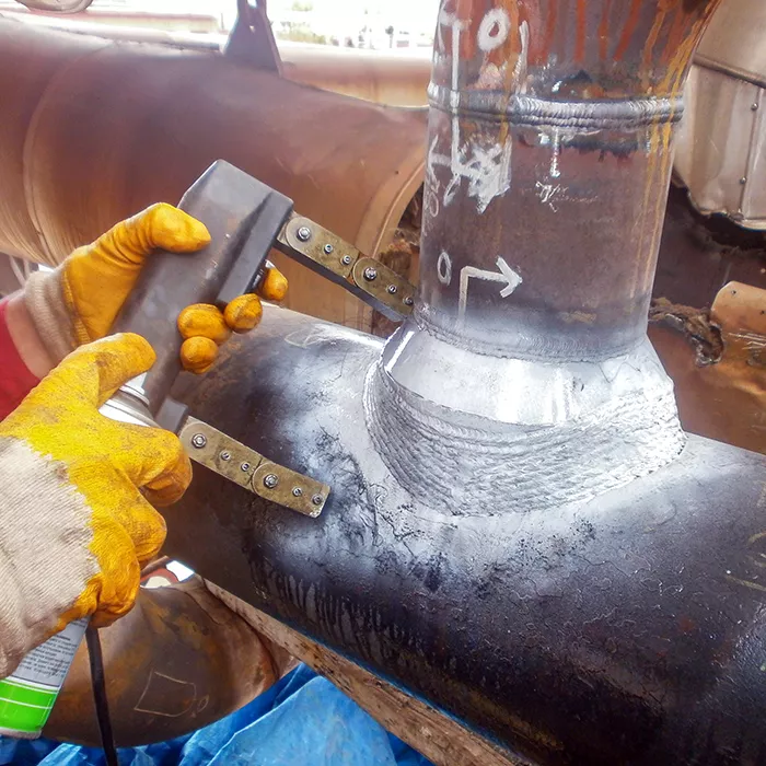 inspector is testing with magnetic particle inspection method to weldolet of the pipeline