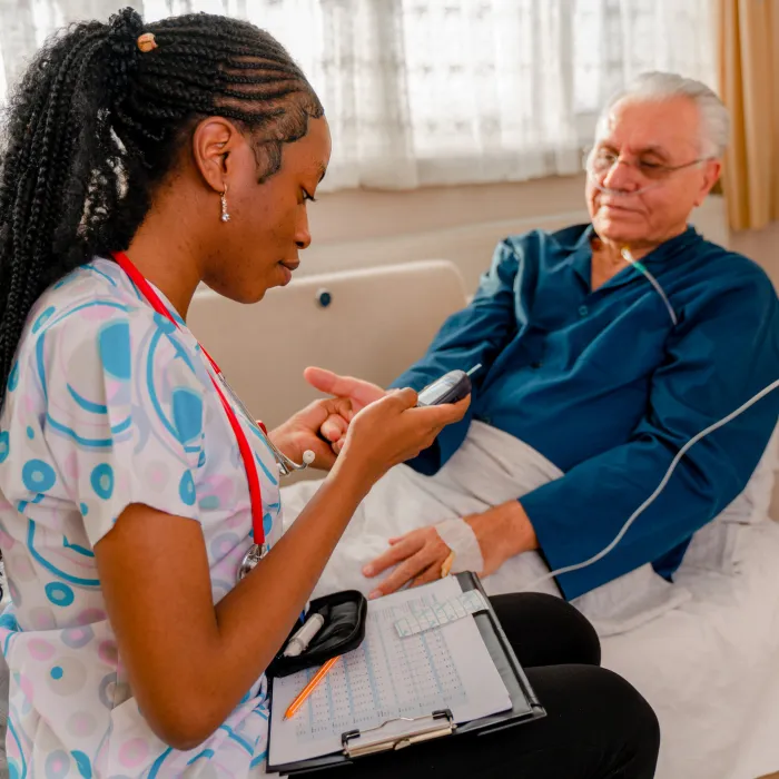  Nurse tests her senior adult patient's high blood sugar with a glucometer 