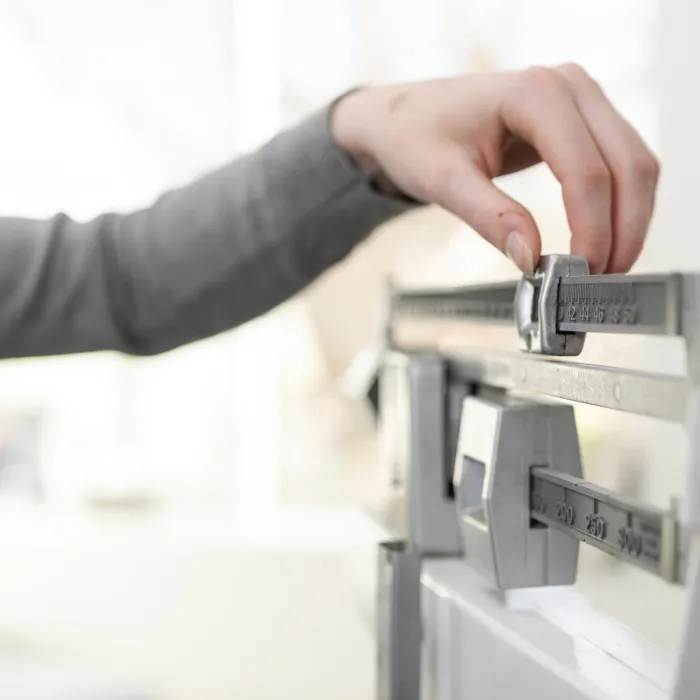 Close-up unrecognizable woman adjusting beam scale in doctor's examination room