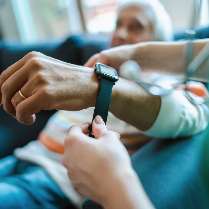 An elderly patient being fitted with a digital health wrist wearable