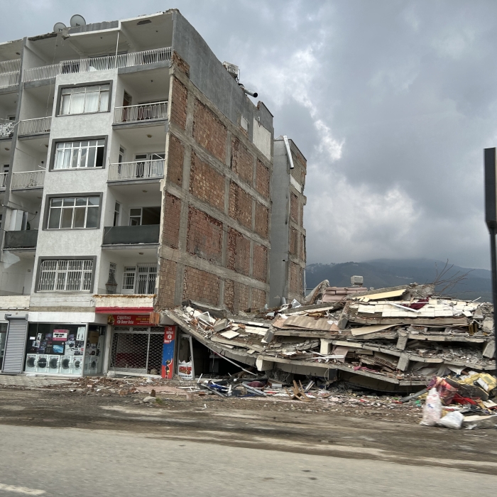 A completely collapsed building on the right on of one still standing following the Turkey earthquake