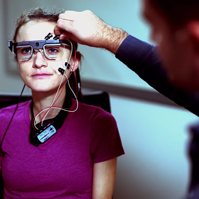 Exponent scientists attach bio sensors to a young person in a user experience lab to monitor movement. 