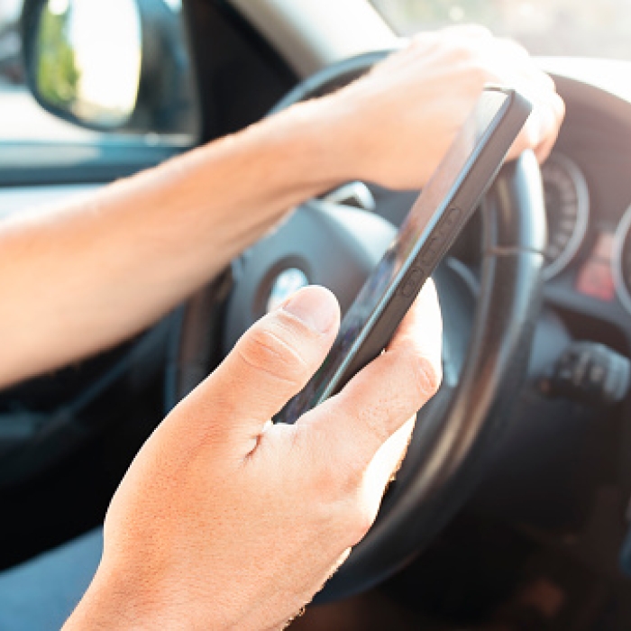 Person holds a phone in right hand while driving