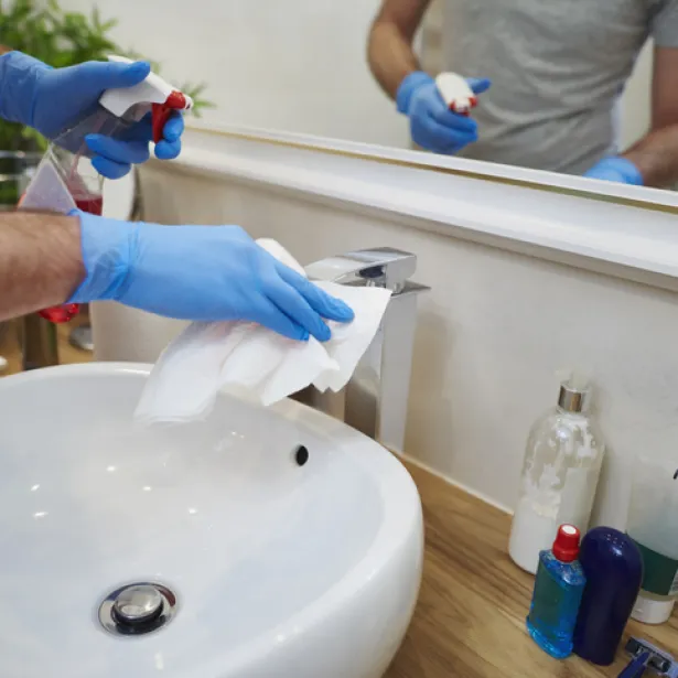 Using chemical to clean a bathroom sink. Exponent analyzes and helps improve safety and performance of household chemicals.