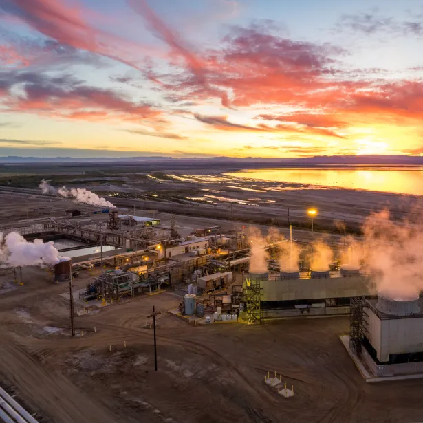 Aerial view of steam rising above an industrial Geothermal Power Plant, Salton Sea in the distance