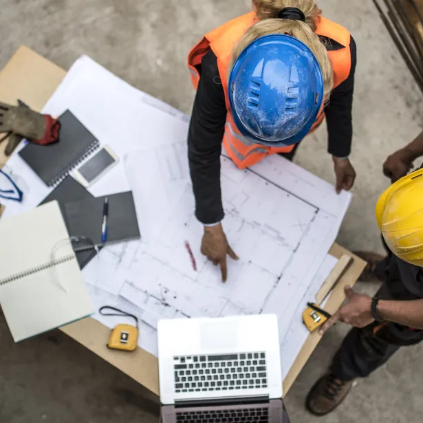 Two architects examining the blueprints on construction site