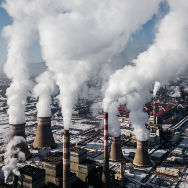 Industrial smoke stacks emit steam in winter 