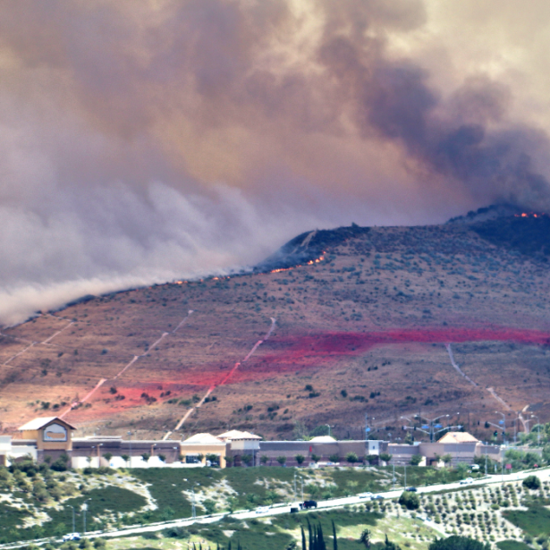 A controlled fire burns on the ridge of a foothill marked for fire management above a town