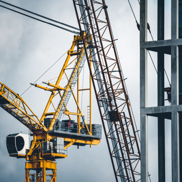 Yellow crane alongside a multi-level building under construction
