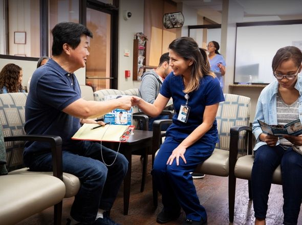A medical professional shakes hands with a patient. Exponent gathers real world data and evidence to improve health science initiatives. 