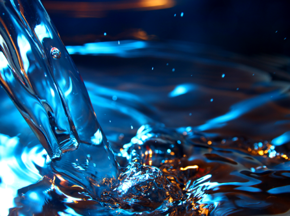 Water flowing into bucket of blue water