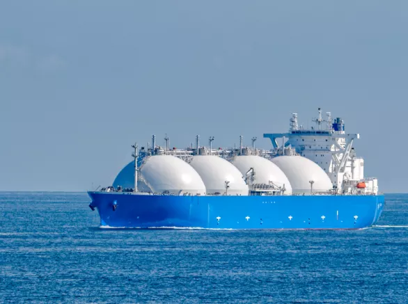Blue ship with four rounded LH2 canisters afloat in the ocean