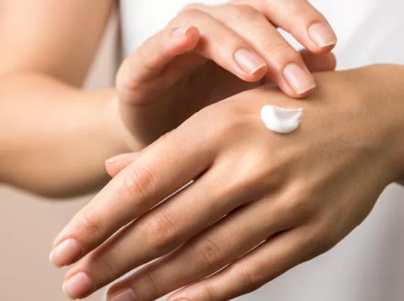 A woman applies hand cream 