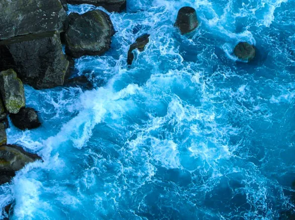 Blue waves of the ocean near the rocks. 