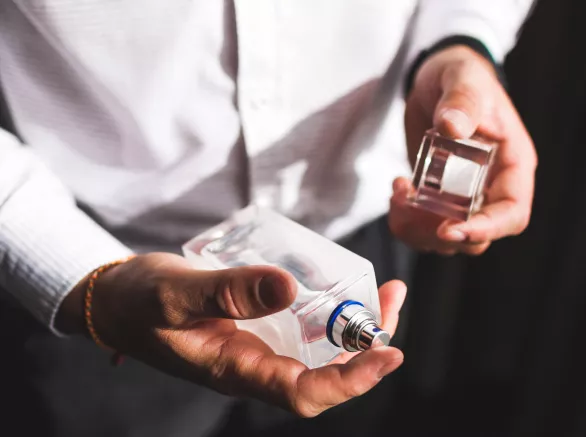 A man spraying a bottle of perfume