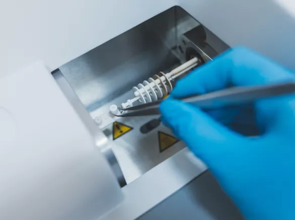 Researcher, doctor, scientist, physicist or laboratory assistant holding test glass tubes and working, experimenting and analyzing in modern lab with equipments, tools and machines