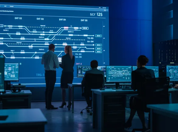 Telecommunications Company System Control and Monitoring Room with Diverse Multicultural Team of Professionals Working on Computers. Big Screen Display Showing Infrastructure Infographics. Back View