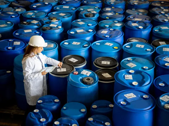 Foreperson doing quality control on a stock of chemical barrels 