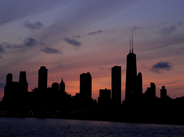 The Chicago Skyline is silhouetted aginst the setting sun.