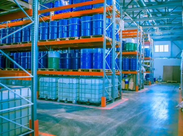 Blue metal barrels. Chemical industry. Metal barrels for chemicals. Warehouse racks. Barrels are kept in stock. Warehouse storage. Logistics in stock.