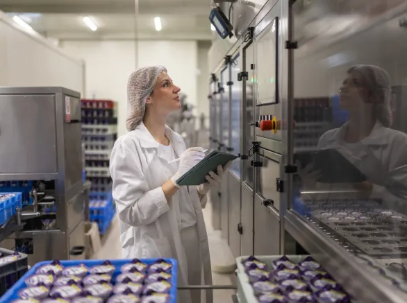 Portrait of woman operating machines at food factory 
